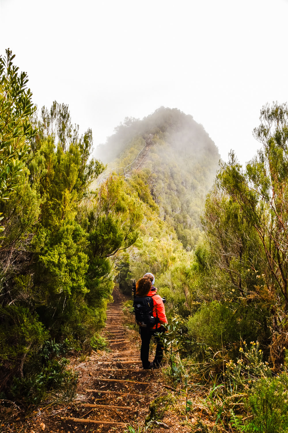 fille sur un sentier devant une vue mystérieuse avec les nuages