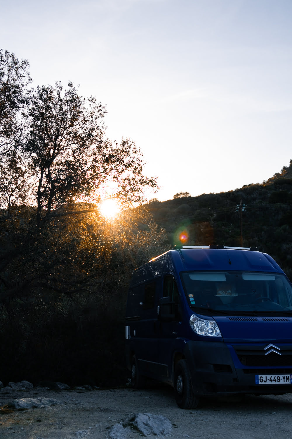 coucher de soleil avec un fourgon bleu
