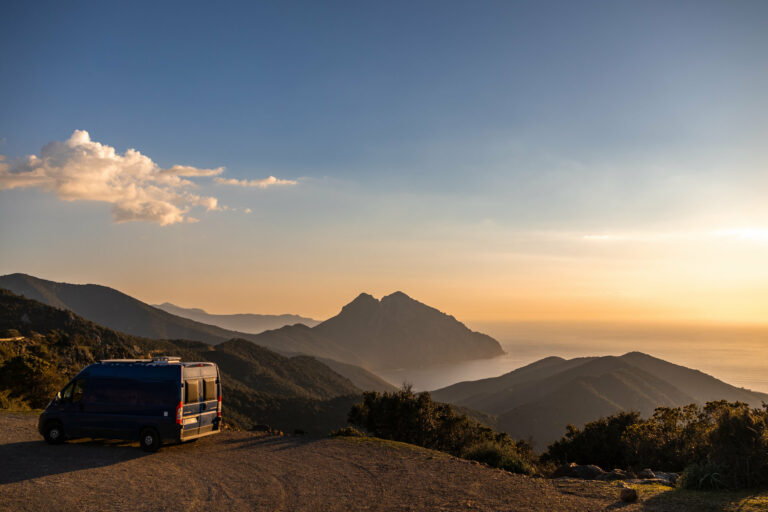 paysage corse avec un van garé et un coucher de soleil sur la mer