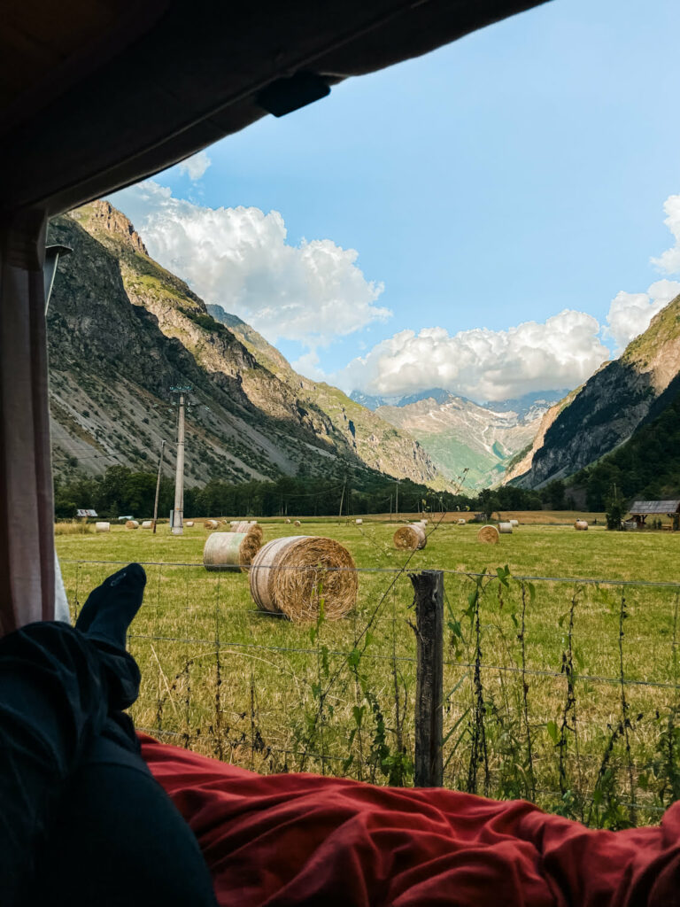 vue depuis un van sur le pré avec du foin et des montagnes