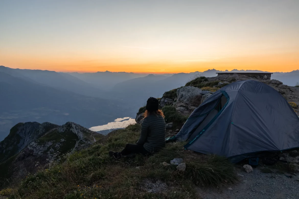 bivouac face à un coucher de soleil avec lac et montagne
