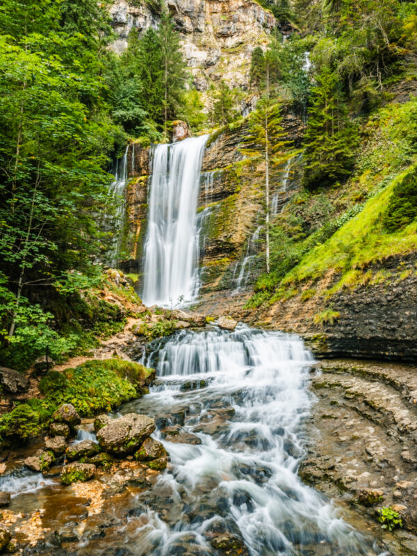 tirage photo de cascade dans foret entouré de rocher