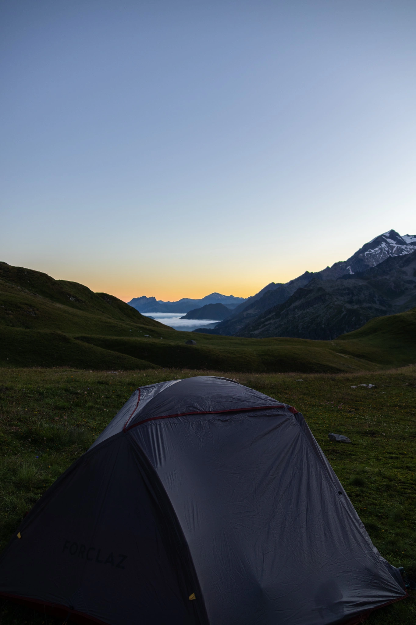 photo d'une tente dans un alpage avec un couché de soleil