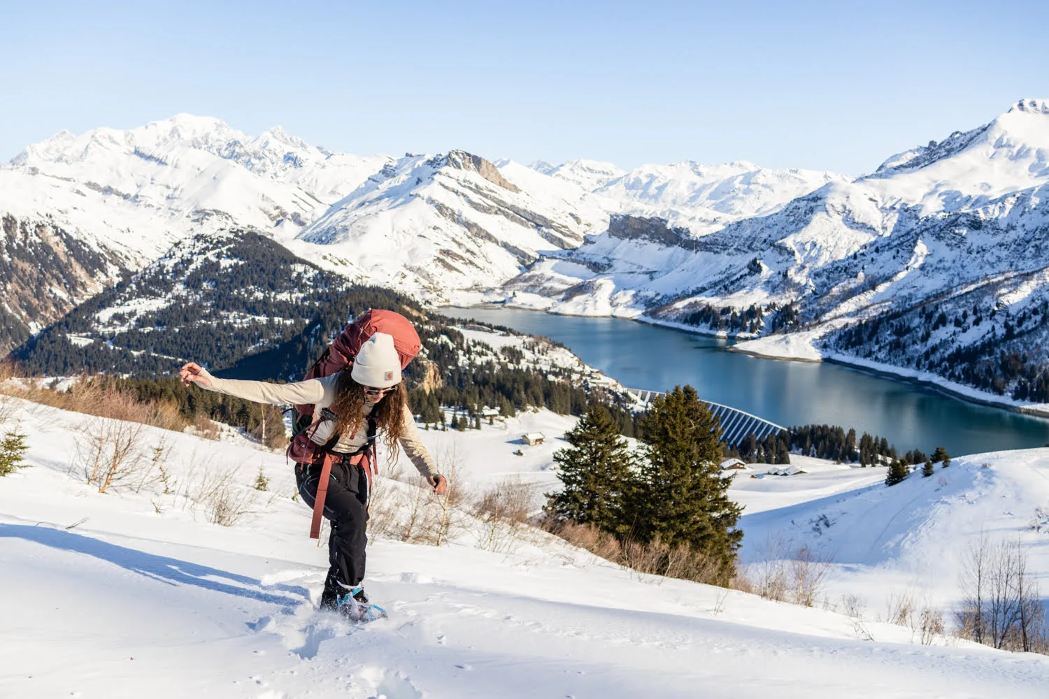 paysage de montagne enneigé et lac avec une randonneuse