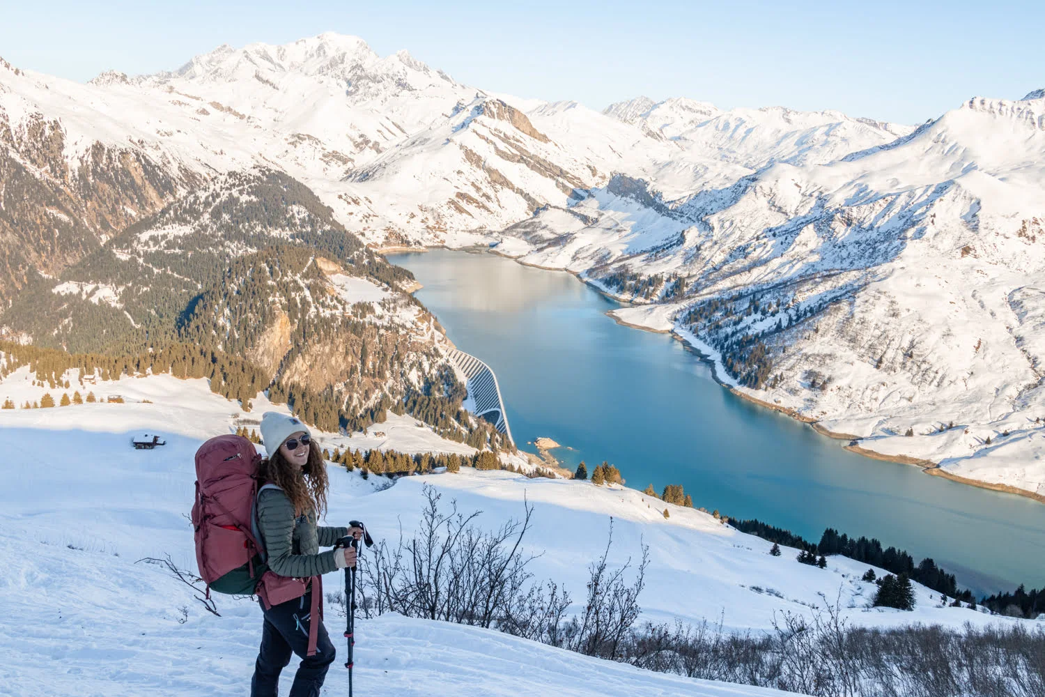 paysage de montagne enneigé et lac avec une randonneuse