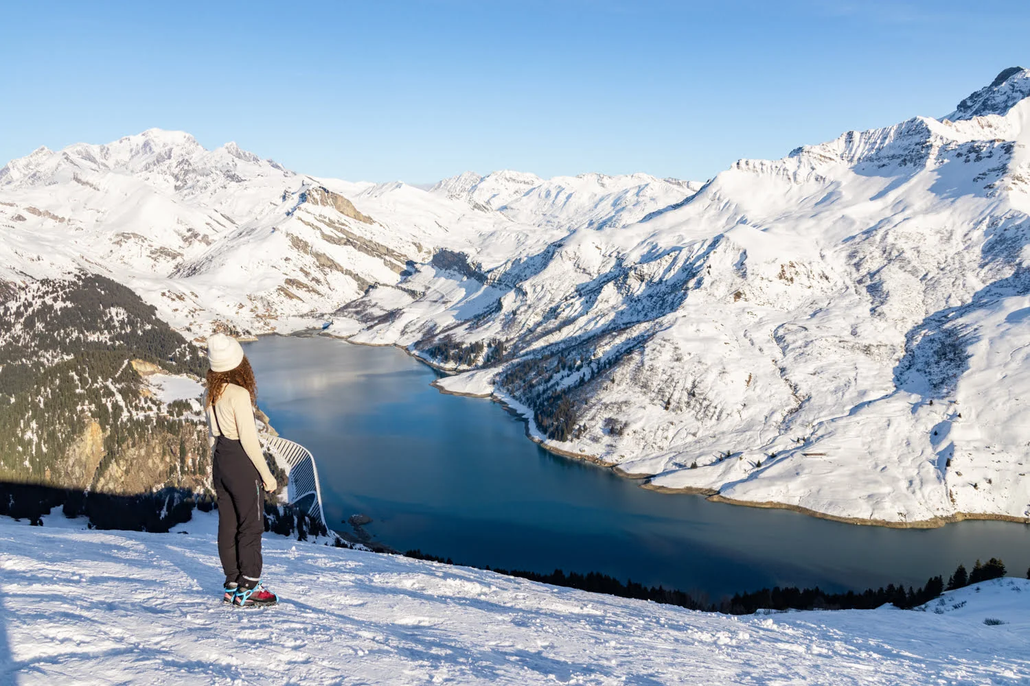 paysage de montagne enneigé et lac avec une randonneuse