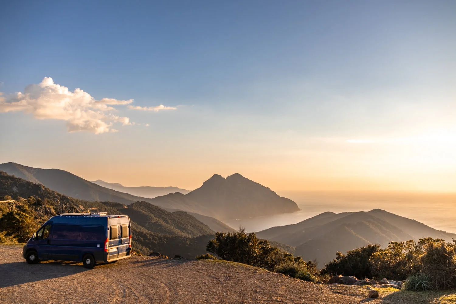 paysage de montagne et mer au coucher du soleil avec un van