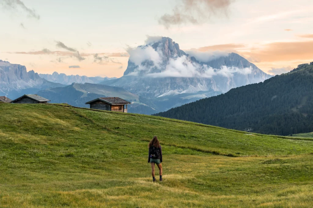paysage de montagne au coucher de soleil avec une randonneuse devant