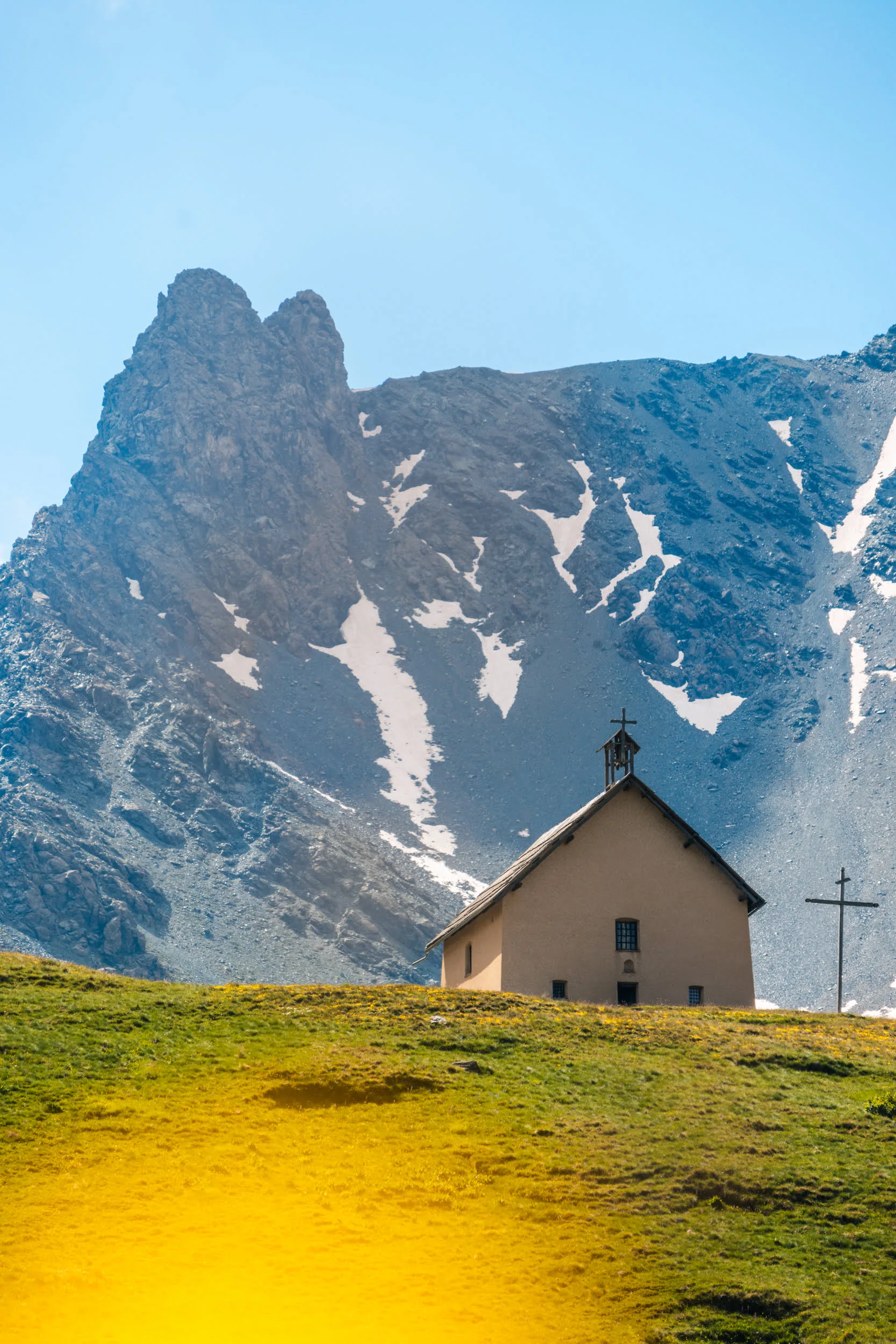 chapelle en montagne avec une fleur jaune