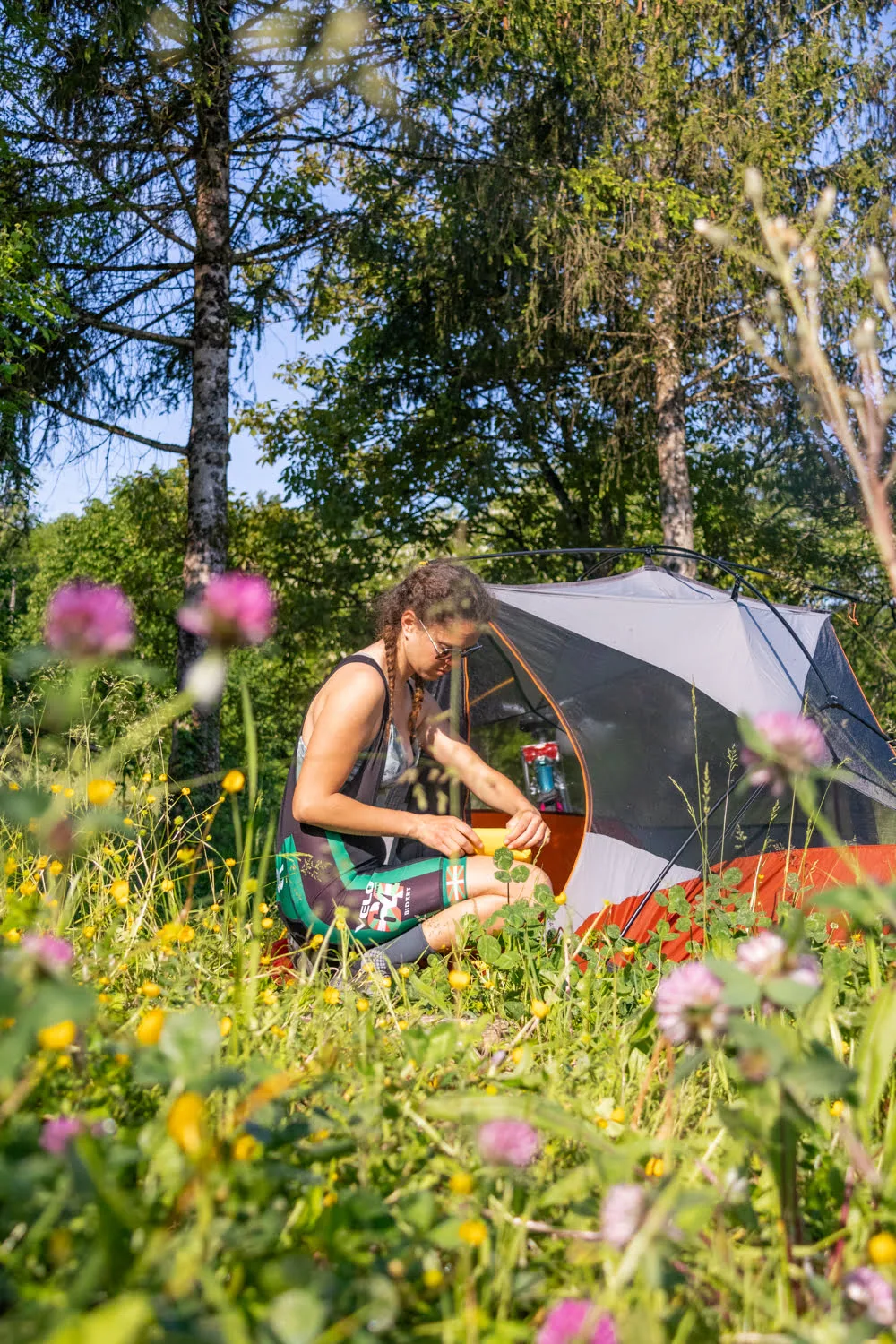 femme devant tente avec des fleurs et arbres