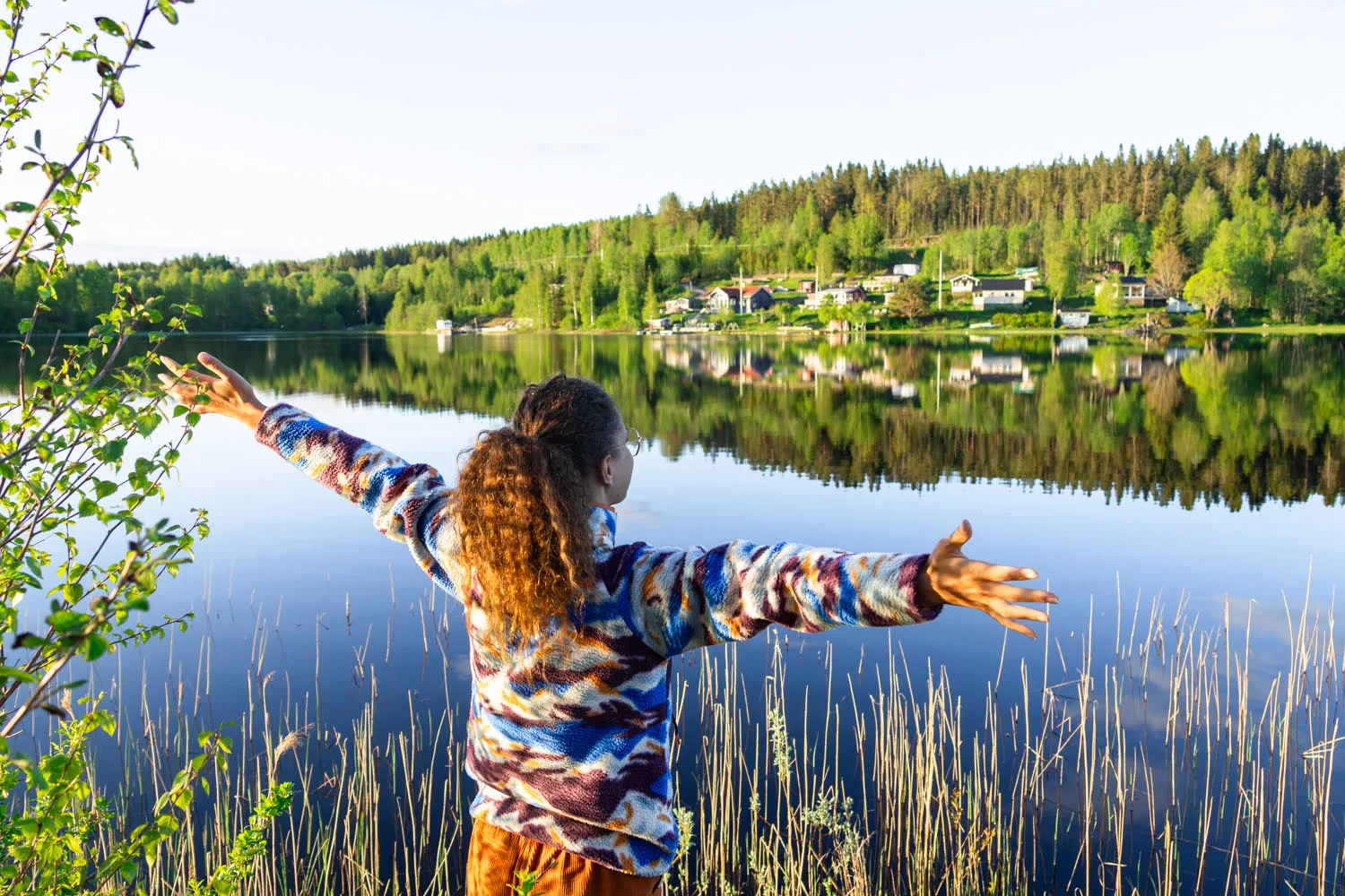 femme bras ouvert devant un paysage avec lac