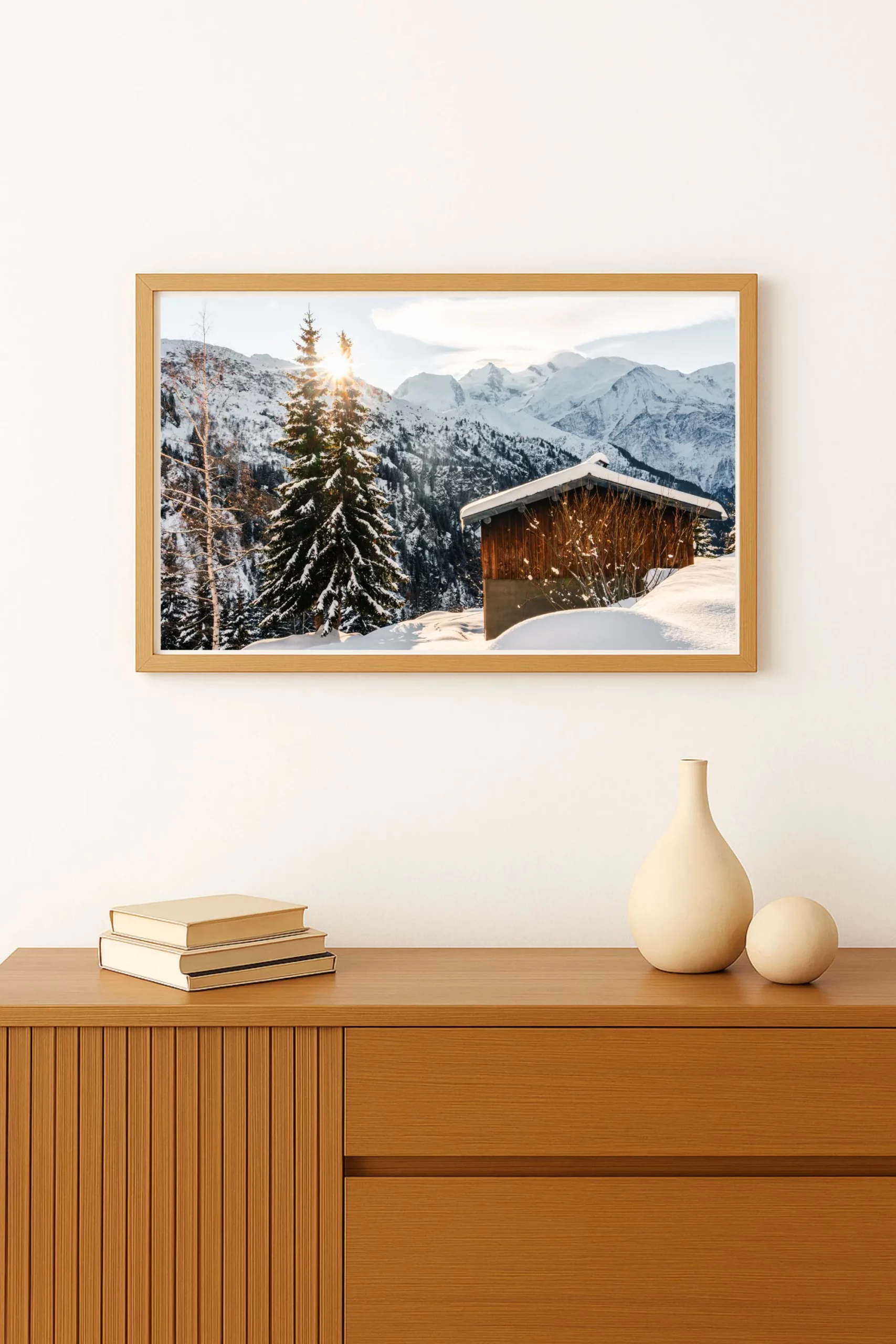 cadre d'une photo d'un Chalet traditionnel avec vue directe sur les sommets enneigés du massif du Mont-Blanc et le soleil. Format Paysage