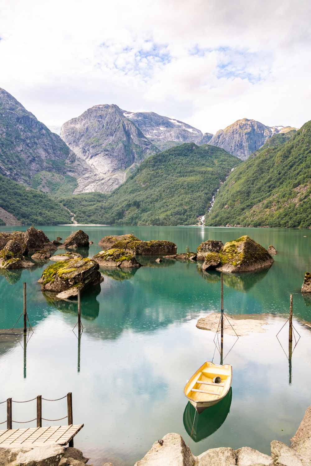 photo du lac Bondhusvatnet aux eaux turquoise niché au pied du glacier, avec ses petites barques