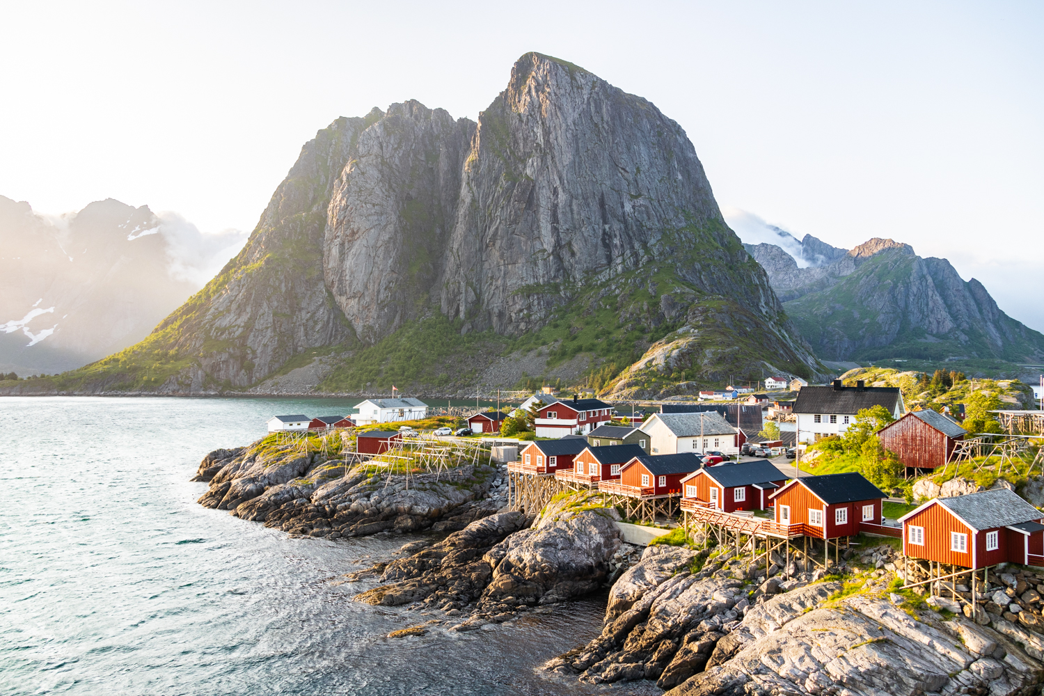 photo du village de pêcheurs de Hamnøy avec ses cabanes rouges traditionnelles au bord du fjord, dans les Lofoten. Format Paysage