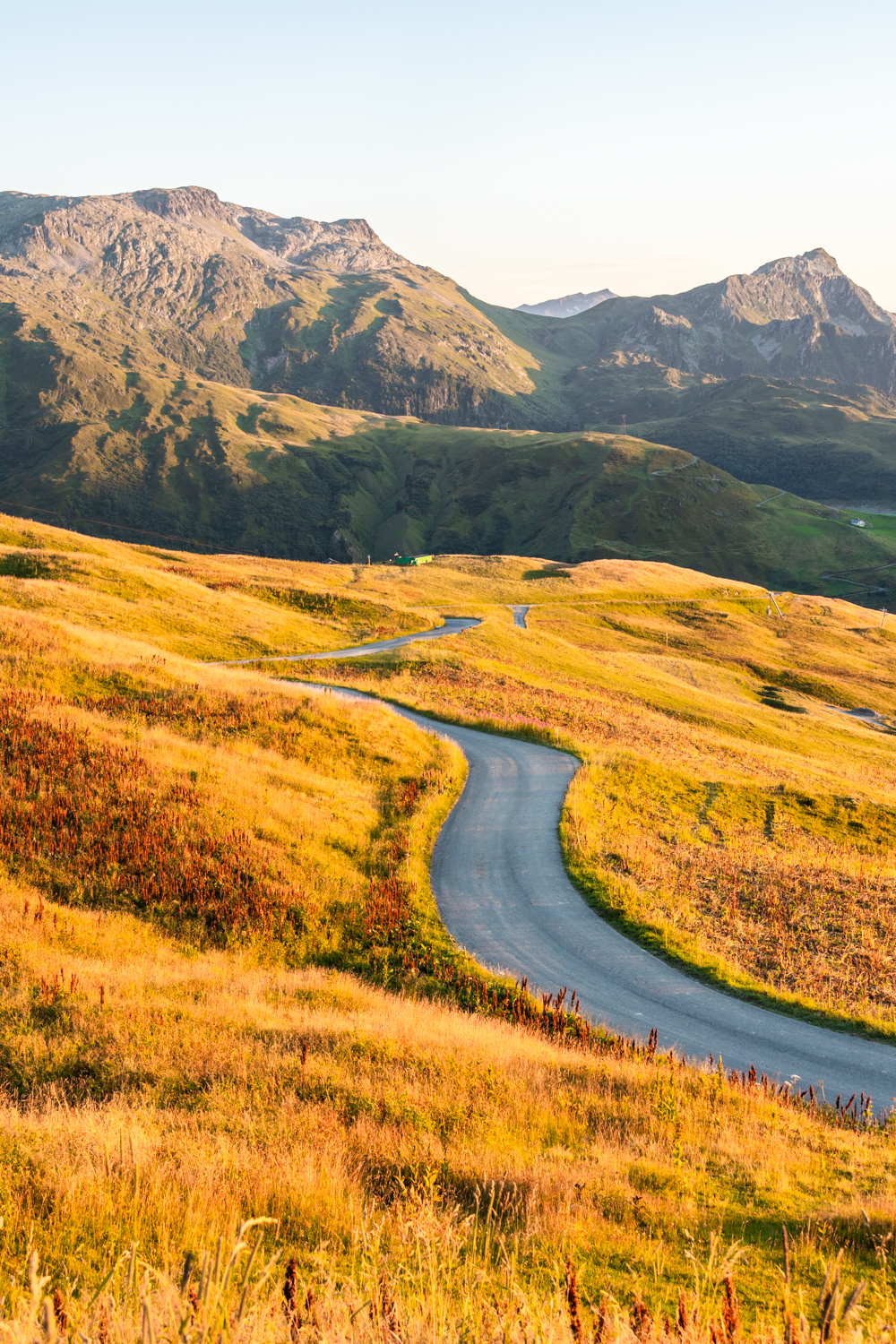 photo d'une Route sinueuse serpentant à travers les paysages montagneux entre vallées et sommets